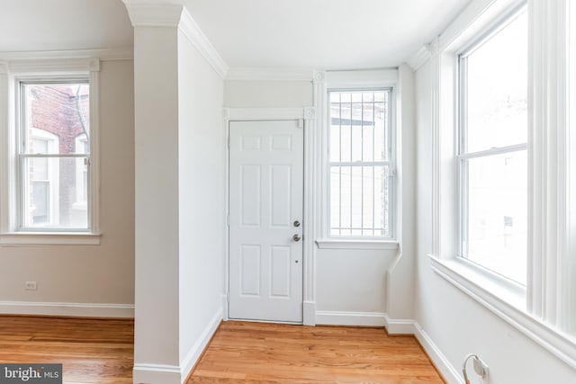 entryway with light hardwood / wood-style flooring and ornamental molding