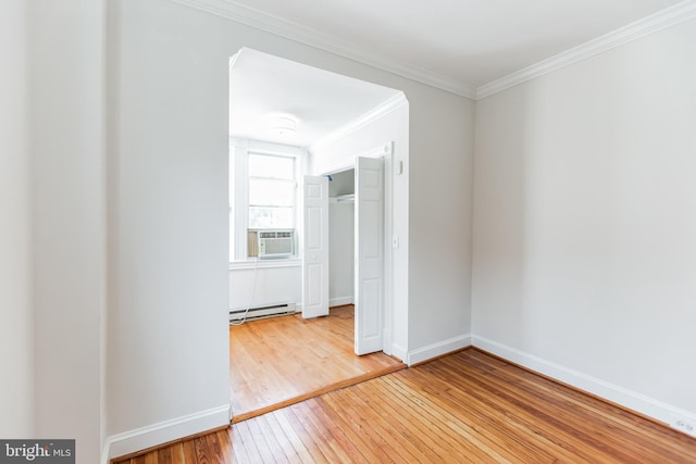 spare room featuring ornamental molding, cooling unit, hardwood / wood-style floors, and baseboard heating