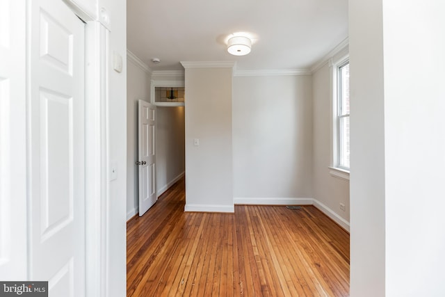 spare room with crown molding, hardwood / wood-style flooring, and plenty of natural light