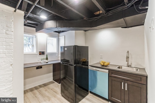 kitchen featuring black refrigerator, stainless steel dishwasher, sink, and light wood-type flooring