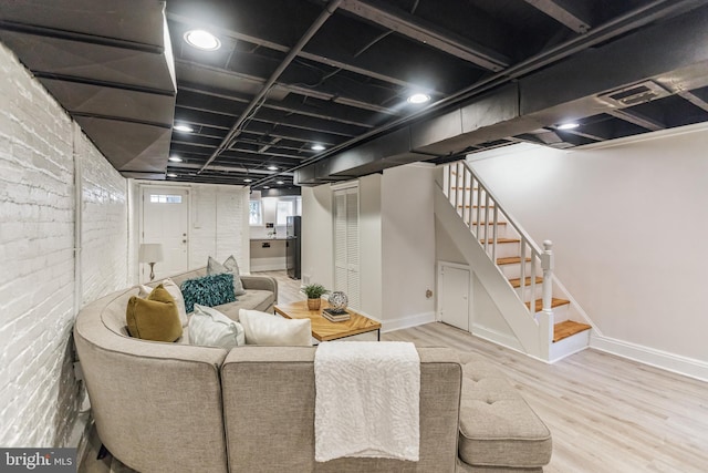 interior space with brick wall and light wood-type flooring