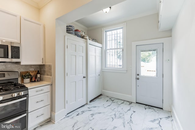 kitchen with appliances with stainless steel finishes, backsplash, light tile patterned floors, and crown molding