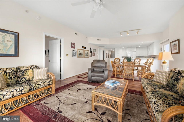 living room featuring ceiling fan, rail lighting, and light hardwood / wood-style floors