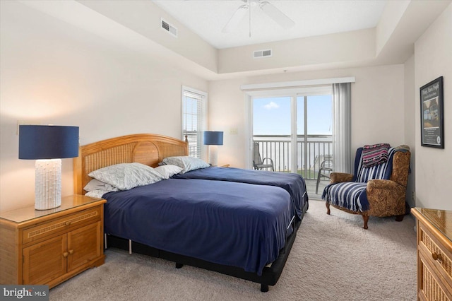 bedroom featuring ceiling fan, access to outside, light colored carpet, and multiple windows