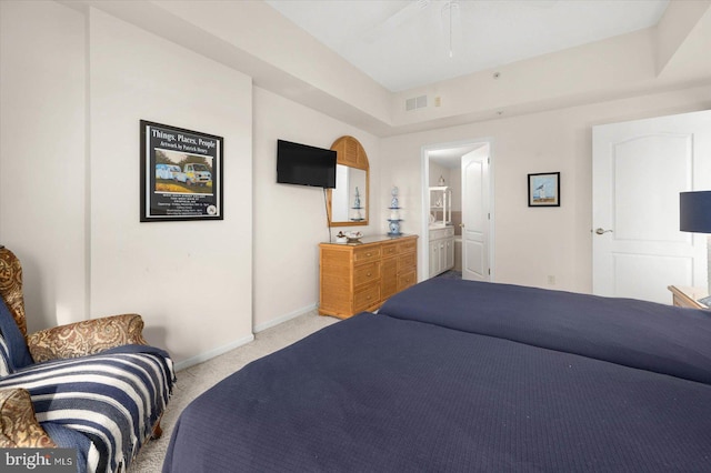 carpeted bedroom with ensuite bath and ceiling fan