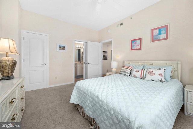 bedroom featuring light carpet, ceiling fan, and ensuite bathroom