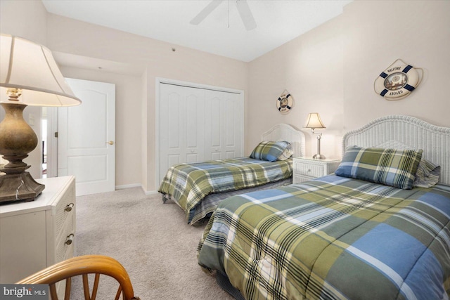 bedroom with ceiling fan, light carpet, and a closet