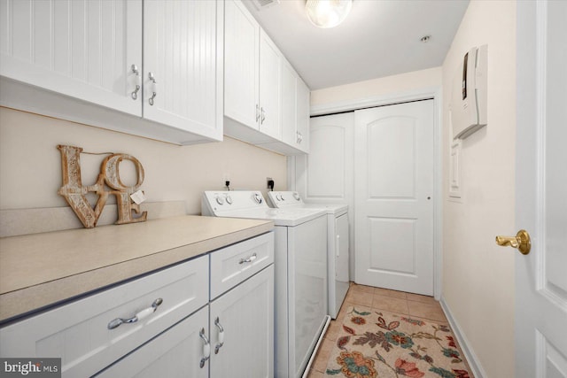 clothes washing area with independent washer and dryer, cabinets, and light tile patterned flooring