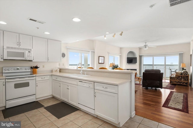 kitchen featuring light tile patterned flooring, sink, white appliances, and a healthy amount of sunlight