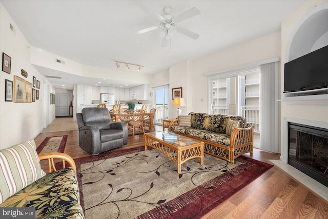 living room featuring light hardwood / wood-style floors and ceiling fan