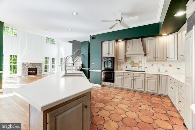 kitchen featuring plenty of natural light, a fireplace, premium range hood, and ceiling fan