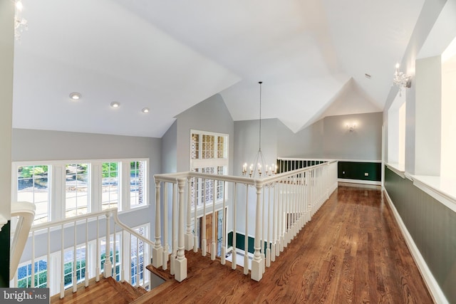 hall with lofted ceiling, an inviting chandelier, and dark hardwood / wood-style flooring