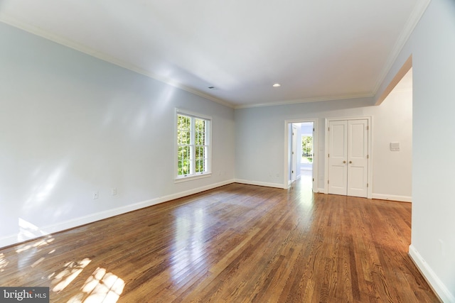 spare room featuring hardwood / wood-style flooring, a wealth of natural light, and ornamental molding