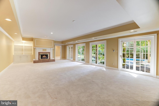 unfurnished living room featuring crown molding, light carpet, and a brick fireplace