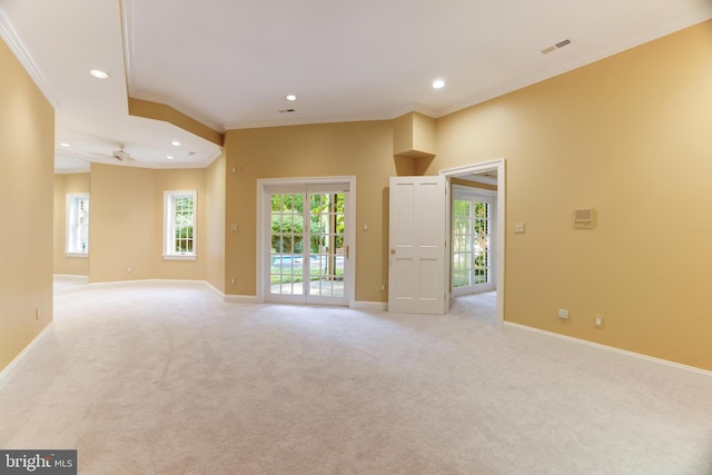 unfurnished room featuring ceiling fan, light colored carpet, and crown molding