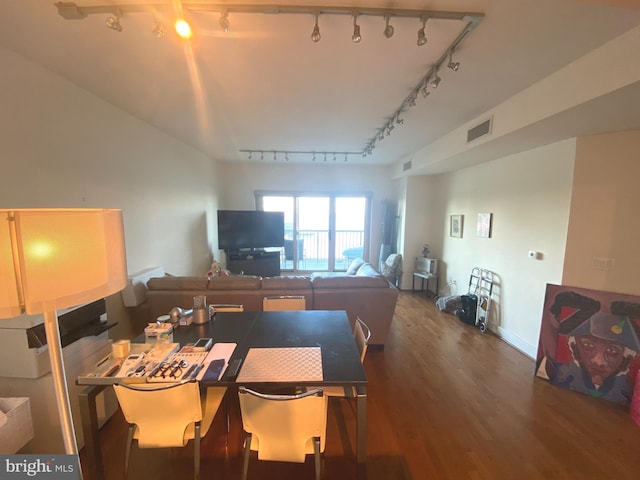 dining area featuring rail lighting and dark hardwood / wood-style floors