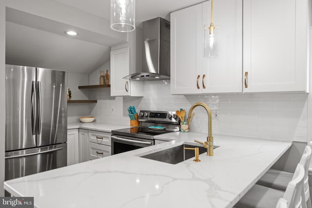 kitchen featuring decorative light fixtures, appliances with stainless steel finishes, light stone counters, and wall chimney exhaust hood