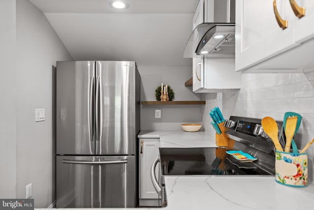 kitchen featuring light stone countertops, range hood, tasteful backsplash, stainless steel appliances, and white cabinets