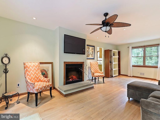 living room featuring ceiling fan and light hardwood / wood-style floors