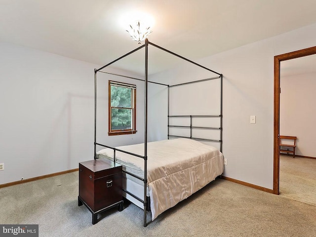 bedroom featuring baseboards and light colored carpet