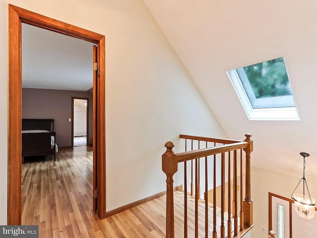 stairs with a skylight, baseboards, and wood finished floors