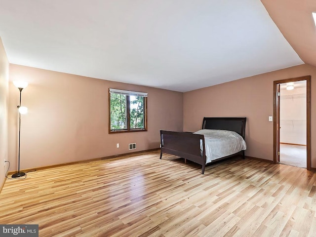 unfurnished bedroom featuring a walk in closet and light hardwood / wood-style floors