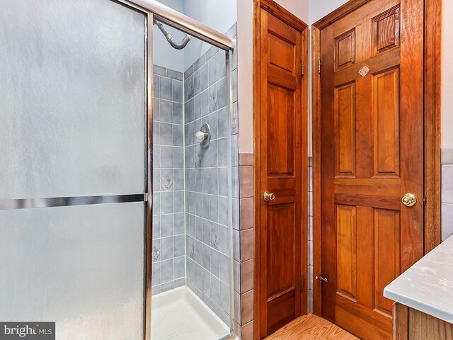 bathroom with vaulted ceiling with skylight, toilet, and tile walls