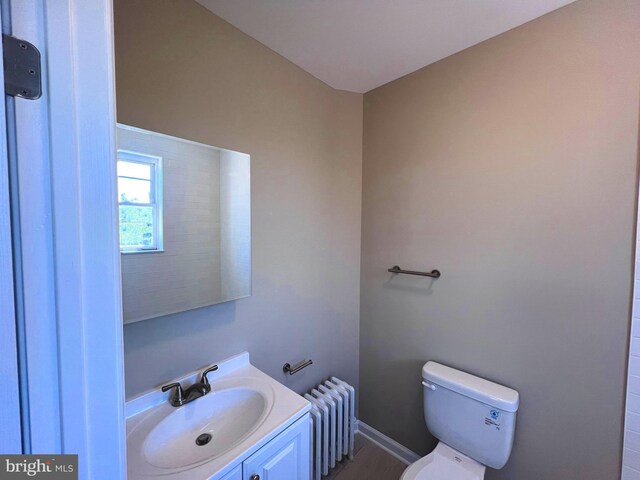 bathroom featuring a tile shower, vanity, and toilet