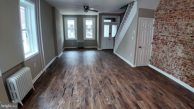 entryway with dark wood-type flooring, radiator heating unit, and a wealth of natural light