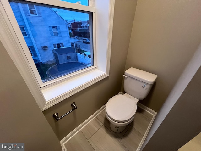 bathroom with toilet and tile patterned floors