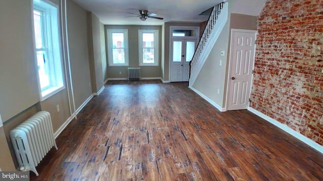 entrance foyer featuring dark wood-type flooring, a healthy amount of sunlight, and radiator heating unit