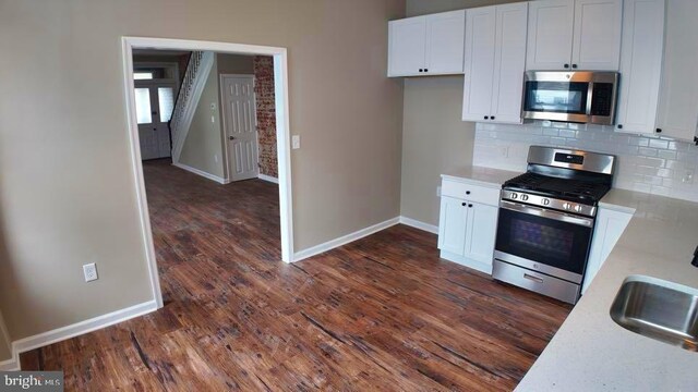 entrance foyer featuring radiator, brick wall, ceiling fan, and wood-type flooring