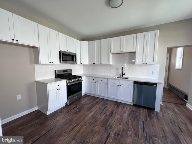 kitchen with a baseboard heating unit, dark hardwood / wood-style flooring, appliances with stainless steel finishes, white cabinetry, and sink