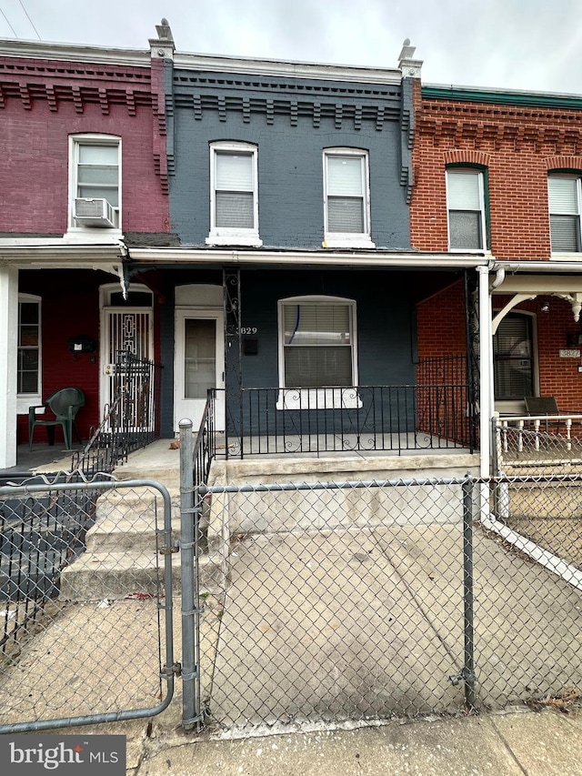 townhome / multi-family property featuring cooling unit and a porch