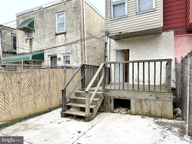 rear view of house with a wooden deck and a patio area