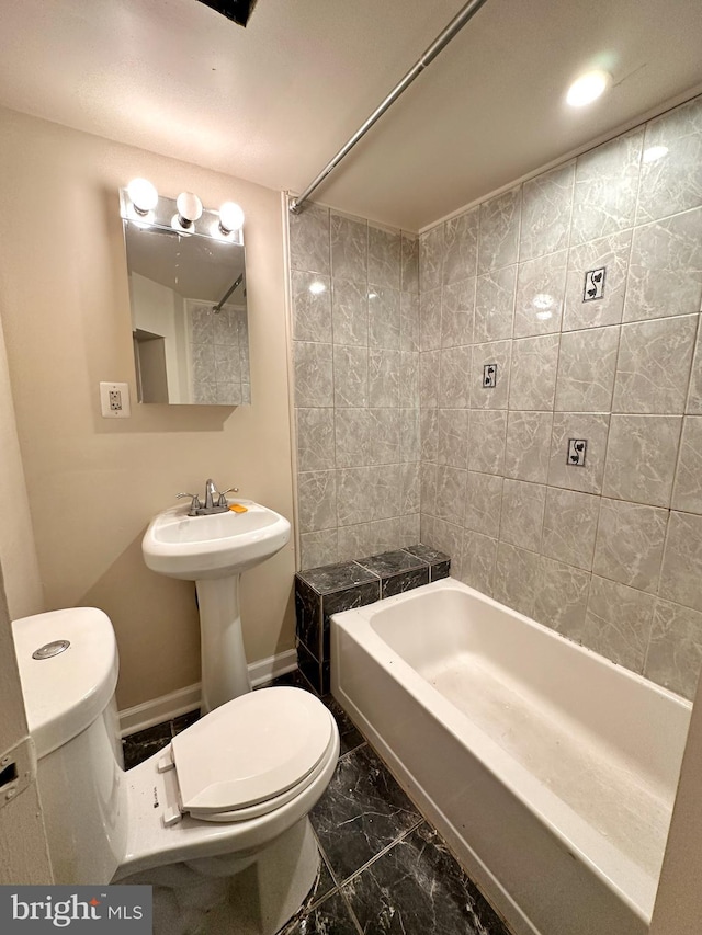 bathroom featuring tiled shower / bath, toilet, and tile patterned floors