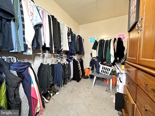 walk in closet featuring light carpet