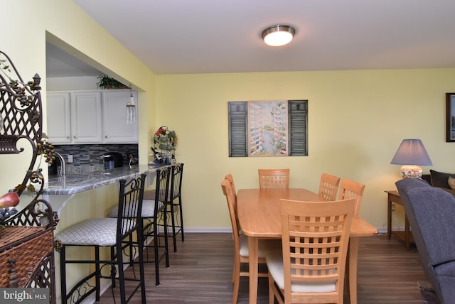 dining room with indoor bar and dark hardwood / wood-style floors