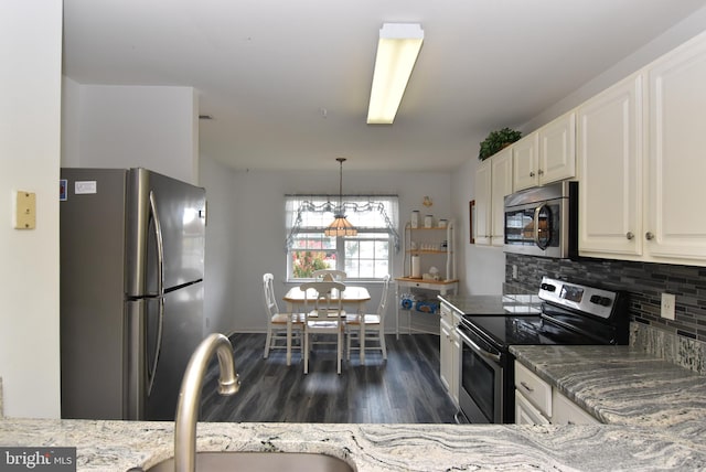 kitchen with dark hardwood / wood-style floors, pendant lighting, appliances with stainless steel finishes, a chandelier, and white cabinets