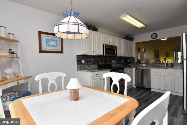 kitchen with white cabinets, stainless steel appliances, sink, dark wood-type flooring, and tasteful backsplash