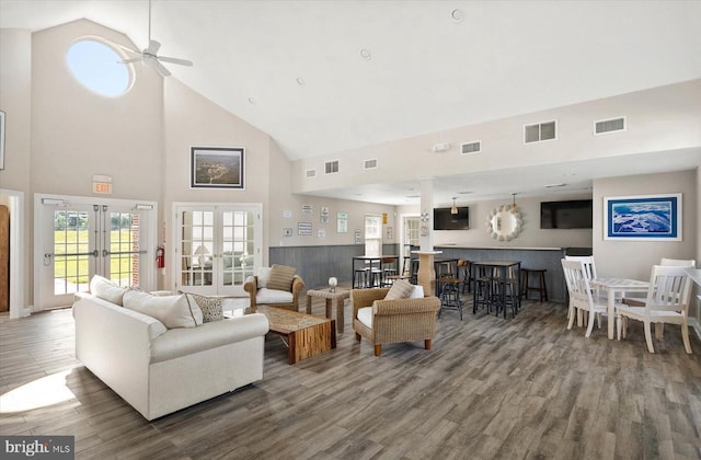 living room with high vaulted ceiling, ceiling fan, wood-type flooring, and french doors