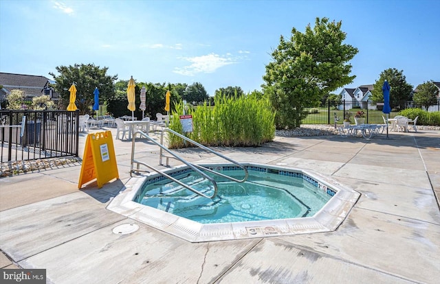 view of swimming pool with a hot tub