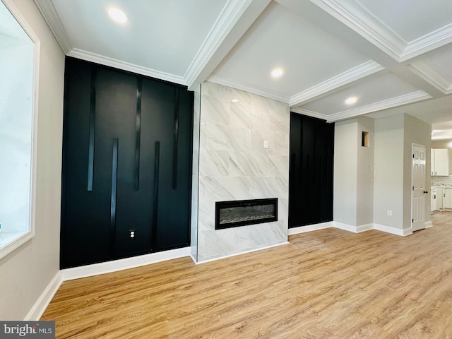 unfurnished living room with light wood-type flooring, a high end fireplace, crown molding, and baseboards