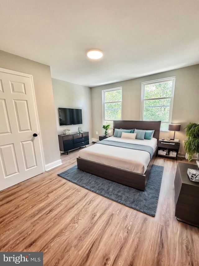 bedroom featuring light wood-style flooring and baseboards