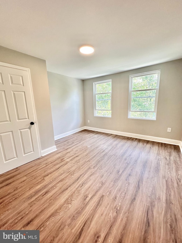 empty room with baseboards and wood finished floors