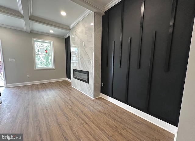 unfurnished living room with ornamental molding, coffered ceiling, hardwood / wood-style flooring, beamed ceiling, and a fireplace