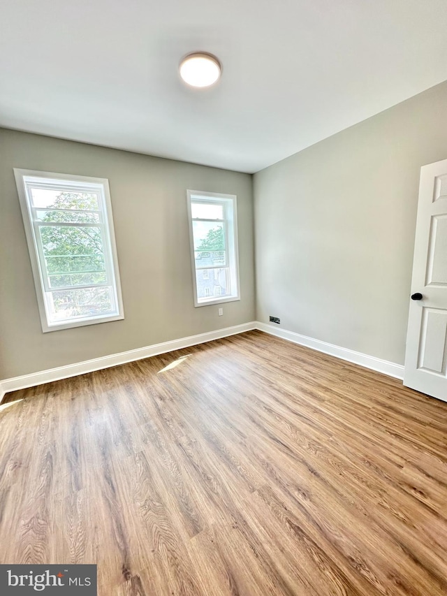 unfurnished room with light wood-style flooring and baseboards