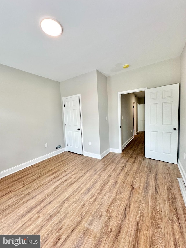 unfurnished bedroom featuring baseboards and light wood-style floors