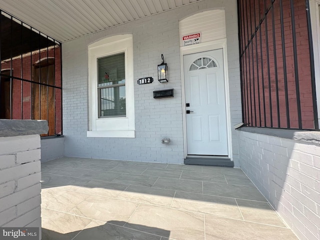 view of exterior entry featuring brick siding