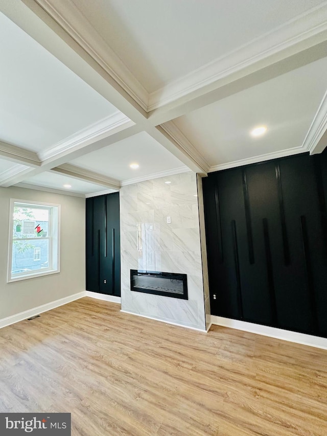 unfurnished living room featuring coffered ceiling, a premium fireplace, crown molding, light wood-type flooring, and beam ceiling